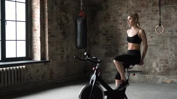 Atractiva Mujer Fitness Montar Bicicleta Estática Gimnasio Plano Medio Una — Vídeo de stock