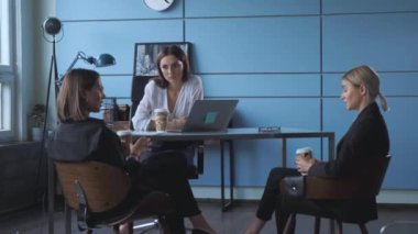 Takım çalışması başarı konsepti. Gündelik kıyafetlerle çalışan yeni kız arkadaşlarla dolu. Konforlu aydınlık ofis toplantı odasında yeni gelişim stratejileri üzerinde tartışıyorlar.