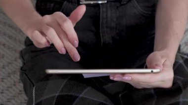 Tablet kullanan genç bir iş kadını. Tablet tutan kadın, sayfaları kaydırıyor. Omzunun üstünden bak.