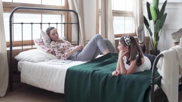 二人の女性が部屋のベッドに横になっている — ストック動画