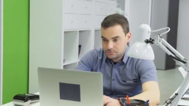 İşadamı odaklı girişimci dizüstü bilgisayarla araştırma yapıyor. Ofis masasında bilgisayar kullanan genç bir profesyonel. Modern teknoloji not defteri üzerinde çalışan meşgul bir işçi..