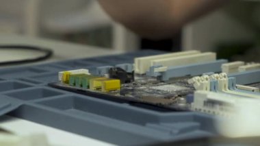 İnsan eliyle büyüteç kullanarak lehimleme yapmak. Mühendis lehim, büyüteç altında bir çip seti. Elektronik bakım mühendisi. Elektronik bileşenler.