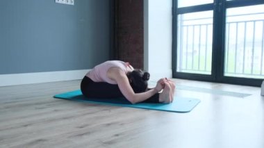 Çekici Hintli kadın sırt kaslarını güçlendirmek ve esnek bir vücut konsepti elde etmek için yoga egzersizleri yapıyor.