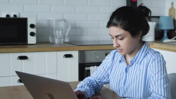 ラップトップを使用してコンピュータで作業する若いインド人女性を閉じます — ストック動画