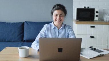 Odaklanmış Hintli kadın mesafe öğretmeni laptop konferansında web kamerası görüntülü konuşma ile öğrenciyle iletişim kuruyor. Dersi açıkla ve bilgisayar eğitimi kavramını öğren.
