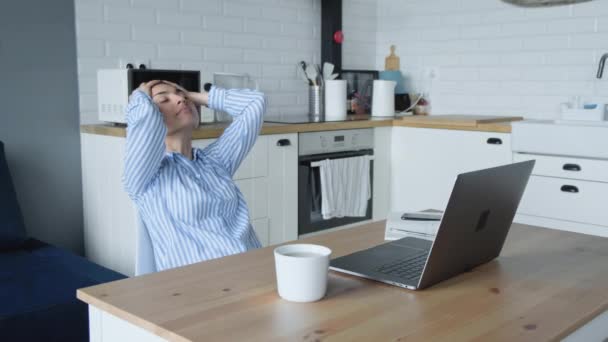 若いインドのビジネス女性の労働者は オフィスの机の上に座ってリラックスノートパソコンの仕事を終えた頭の後ろに手を置く仕事に満足しています — ストック動画