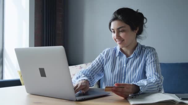 クレジットカードを持っている若い女性の顧客と自宅に座ってコンピュータを笑顔 幸せな女性の買物客はオンライン店で購入を作る即座に容易なオンライン支払を使用して 電子銀行アプリサービス — ストック動画