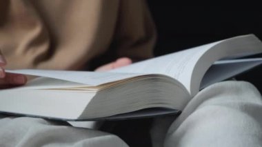 Sayfaları çeviren elleri olan kitabın yakın çekimi. Kitap sayfalarını aç