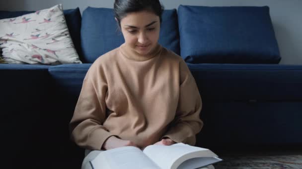 Young Indian Woman Sitting Sofa Reading Book — Stock Video