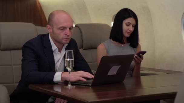 부부가 컴퓨터를 사용하는 여자가 자신의 사업용 비행기에서 컴퓨터를 사용하는 사업을 — 비디오