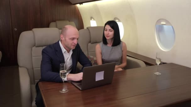 Bilgisayarda Çalışan Genç Bir Çift Erkek Şampanya Içen Özel Jet — Stok video