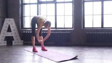 Yoga odasındaki büyük bir pencerenin yanında esneme hareketi yapan bir kadın. Güç, eğitim..
