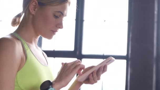 Close Uma Jovem Loira Fazendo Usando Smartphone Assistindo Plano Treino — Vídeo de Stock