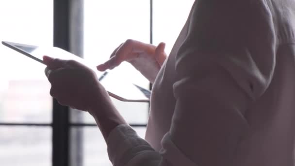 在一间明亮的办公室里 一个女人手压在一块靠近大窗户的桌子上的触摸屏上的侧视图 — 图库视频影像