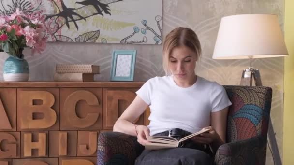 Ung Kvinde Læser Bog Hyggelig Stue Vender Side Læring Studere – Stock-video