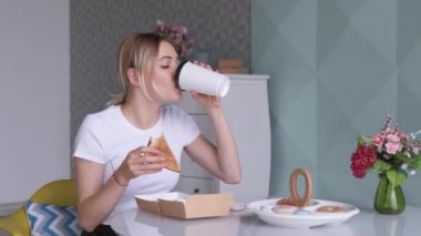 İş yerinde abur cubur. Sarışın kadın beslenme çantasından yemek yiyor.