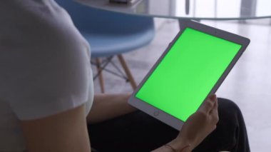 Cafe Hand 'de oturan kadın yeşil ekranlı tablet bilgisayarla internet dokunmatik dokunmatik ekran iletişim kroma parmak mesajı yavaş çekim