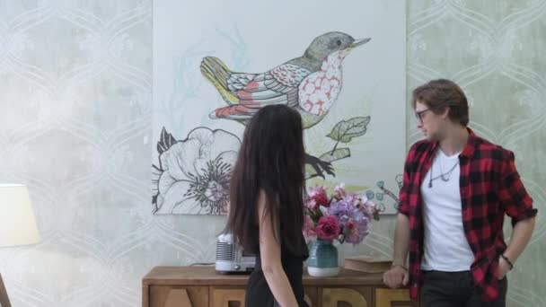 明るい部屋の壁の絵画に立っている若いカップルの閉じる自分のアパート移動 — ストック動画