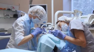 İnsan sağlığı ve diş bakımı, dişçi asistanı olan bir kadın ve profesyonel tıp kliniğinde müşteri olarak ziyaret edilen genç bir kadın. Sabit çekim