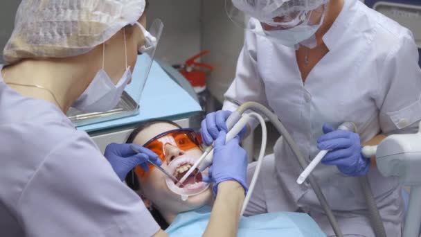 Zbliżenie Dwóch Młodych Dentystek Okularach Pracujących Pacjentem Myjącym Zęby Badającym — Wideo stockowe