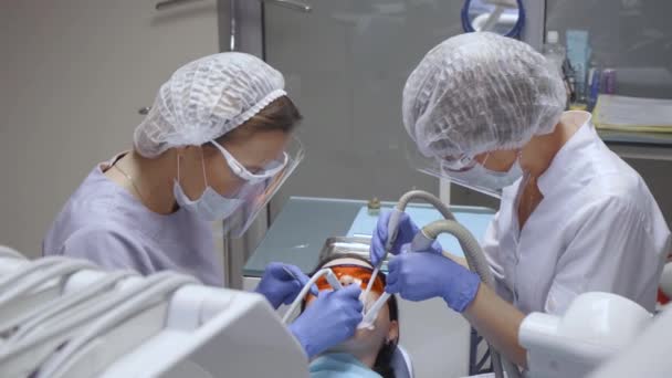 Profesjonalna Dentystka Jej Asystentka Pracują Klientką Siedzącą Krześle Klinika Stomatologiczna — Wideo stockowe