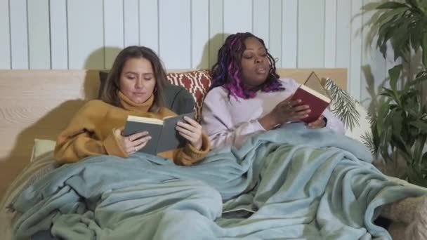 Retrato Mujer Afroamericana Caucásica Acostada Cama Leyendo Libros Muebles Para — Vídeos de Stock