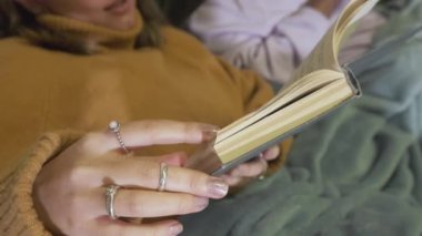 Kitap sayfalarını karıştırarak edebiyat okuyan ve okuyan tatlı bir kız.