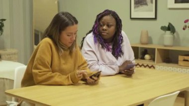 Afro-Amerikan ve Avrupalı Kadınlar Sorunlar Hakkında Konuşuyor Akıllı Telefon Kullan Konforlu bir Apartmanda Bir Masada Otur