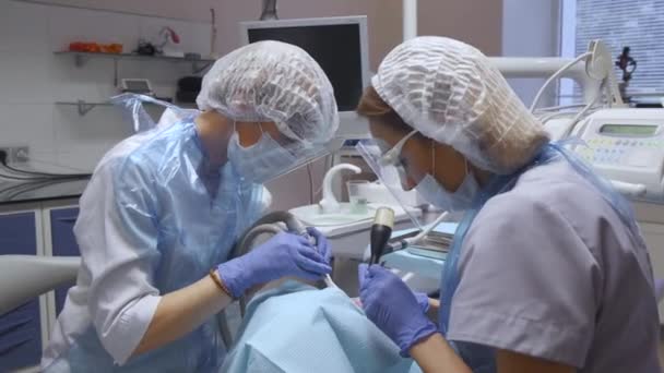 Plan General Dos Dentistas Realizan Operación Los Dientes Del Paciente — Vídeo de stock