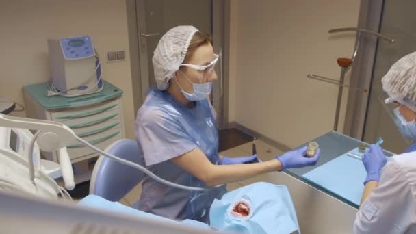 Młoda Kobieta Dwóch Dentystów Leczy Zęby Przez Profesjonalnych Dentystów Szpitalu — Wideo stockowe