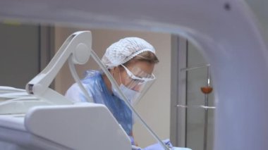 Kadın dişçi, diş kliniğinde bir hastayı tedavi ediyor. Diş muayenesi. Stomatolog hastaların dişlerini tedavi eder. Temizlik, dişçilik.