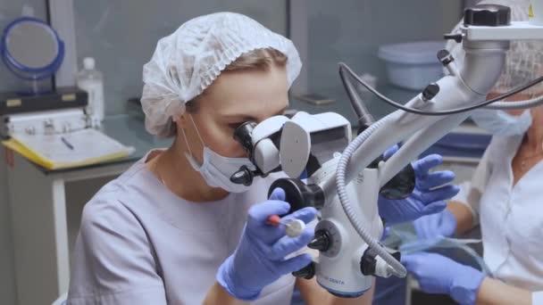 Uma Jovem Dentista Olha Para Microscópio Faz Exame Dos Dentes — Vídeo de Stock