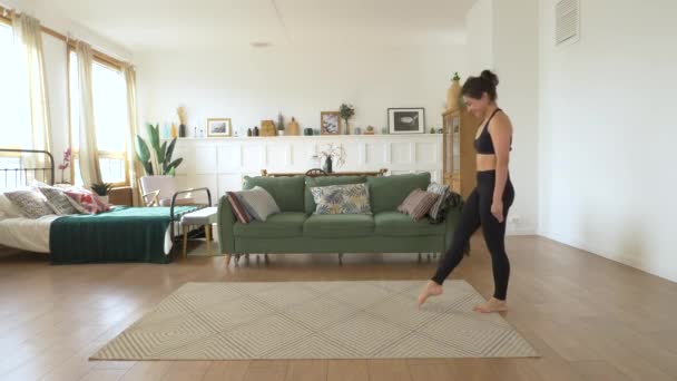 一位年轻的印度体操运动员芭蕾娜在家里坐火车 做手倒立练习 一间明亮舒适的房间 身穿黑色上衣和腿 运动理念健康生活 — 图库视频影像