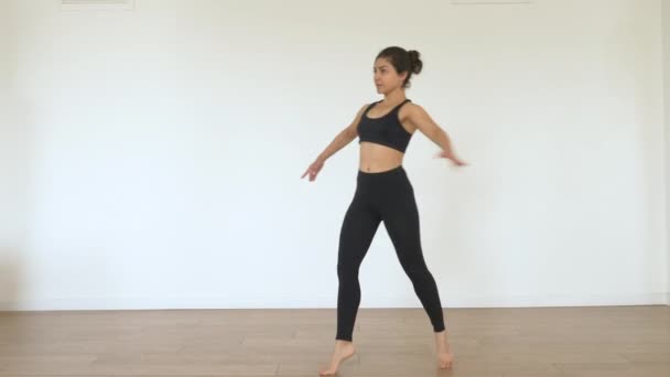 一个年轻的印度芭蕾舞演员在健身房里训练 做旋转练习 穿着黑色上衣和腿 运动理念健康生活 — 图库视频影像