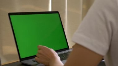 Krom anahtar kullanan yakın plan Hintli kadın masadaki dizüstü bilgisayarı kullanıyor.