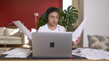 Gülümseyen Hintli Kadın Kablosuz Kulaklık Giyiyor. Laptoptan arıyor. Yeni proje, Belgeler İş Planı, Parlak Konforlu Oda. Ev Eğitimi Bilmeyi ve Finansmanı Öğrenme