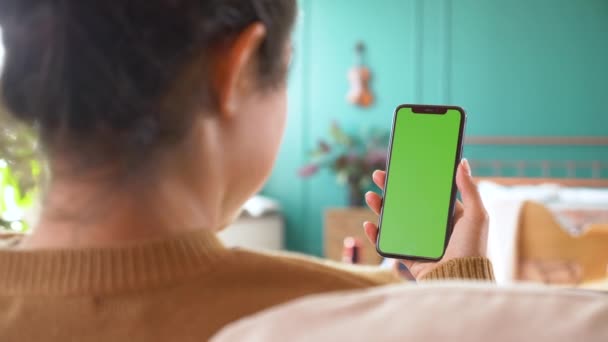 自宅で女性の手にグリーンスクリーンテンプレートスマートフォンのクローズアップショット 女の子はガジェット画面に触れずにコンテンツを見ています 現代の技術と情報の概念 — ストック動画