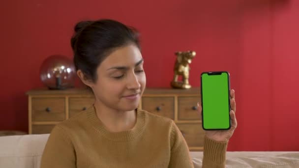 若いインドの女性の持株スマートフォンは 新しいアプリ 緑の画面技術を示しています — ストック動画