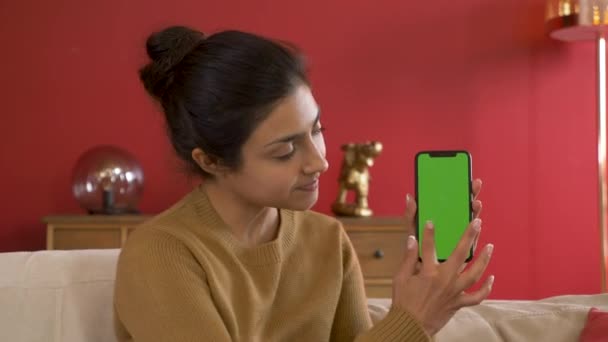 笑顔若いインドの女性は 緑の画面でスマートフォンを表示します ガジェットを使用する新しいアプリを表示すると スワイプ緑の画面技術になります — ストック動画