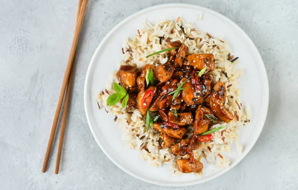 teriyaki chicken\'s  with chili pepper and sesame seeds, with rice. on a white plate, copy space, selective focus, Asian cuisine, Chinese cuisine, Thai cuisine. food flat lay. light background