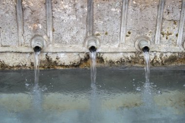 bir taş çeşmenin üç borusu düşen su. yakından görüntülendi