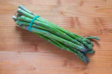 Tahtada izole edilmiş bir avuç taze kuşkonmaz.