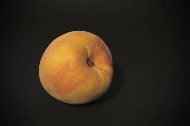 Siyah arka planda sarı şeftali meyveli natürmort