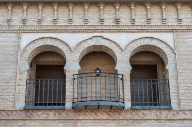 Balkonda üç mudejar tarzı kemer olan modern tuğla cephe