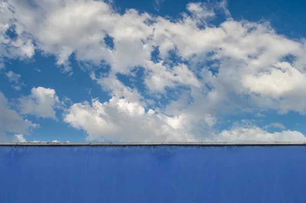 Blau Bemalte Wand Mit Blauem Himmel Und Wolken Hintergrund — Stockfoto