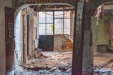 Interior of an abandoned house with debris on the floor and cobwebs