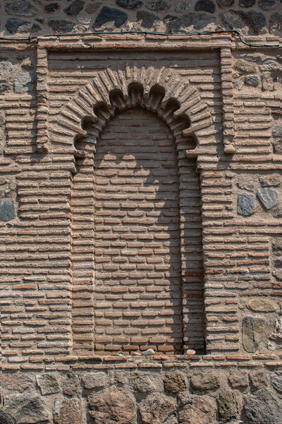 Blind lobed arch in a brick wall of a Mudjar building in Toledo, Spain.