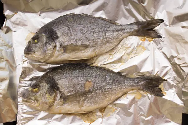 Peixe dorado inteiro grelhado cozido em papel alumínio — Fotografia de Stock