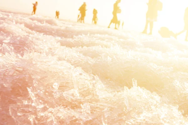 Varias personas se encuentran en el fondo del atardecer del mar — Foto de Stock