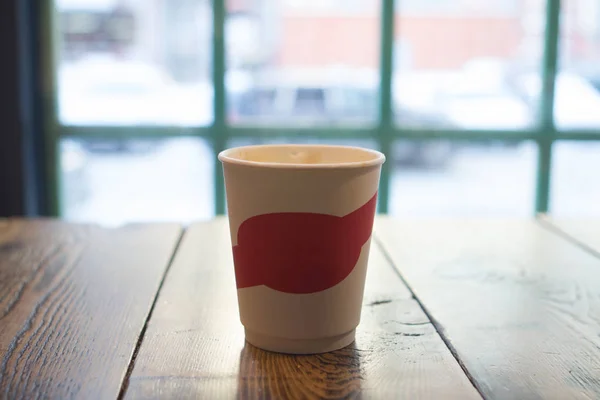 Стакан кофе на деревянном столе с окном в кафе mocap — стоковое фото
